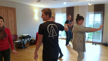 Two adults doing a partner exercise, smiling